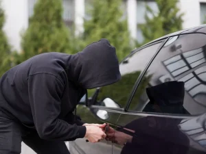 Hooded figure tampering with car door lock, representing disputes over proof in Florida sentencing decisions
