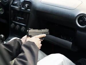 Teen sitting in a car holding a handgun, illustrating a Florida juvenile shooting and youthful offender case