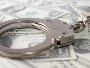 Metal handcuffs on scattered US dollar bills symbolizing Florida criminal appeal about withdrawing a guilty plea