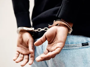 Person in handcuffs from behind after arrest for kidnapping and human trafficking