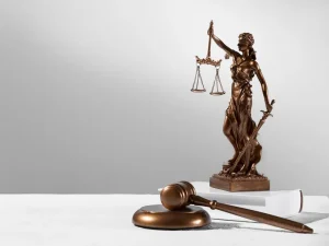 Bronze Lady Justice statue on legal book beside wooden gavel symbolizing Florida death penalty sentencing
