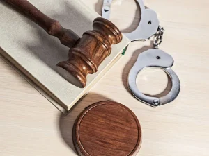 Judge gavel on law book next to handcuffs symbolizing treatment of prior criminal conduct in Florida sentencing