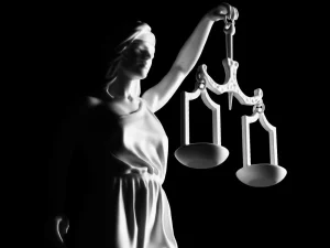 Lady Justice statue holding scales on dark background symbolizing court credit for time served in Florida
