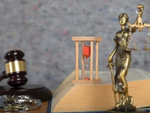 Gavel, handcuffs, hourglass and Lady Justice statue on open law book symbolizing sensitive probation revocation