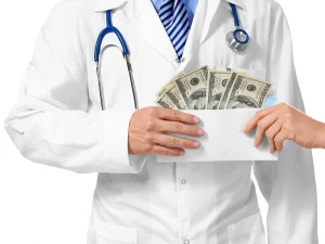 Doctor in a white coat holding an envelope filled with cash as another hand passes it