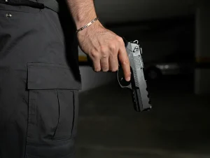 Man holding a handgun in a dark parking garage, symbolizing Florida gun crime charges and challenges to unconstitutional firearm laws