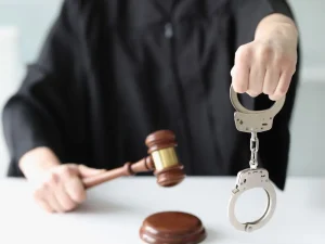 Judge in black robe holds handcuffs and gavel, showing relief from revocation of community control in Florida