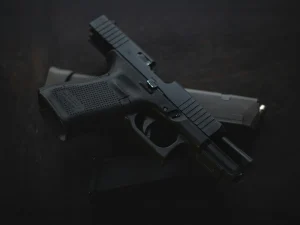 Black handgun with magazine on a dark surface, symbolizing firearm evidence in a Florida conviction case